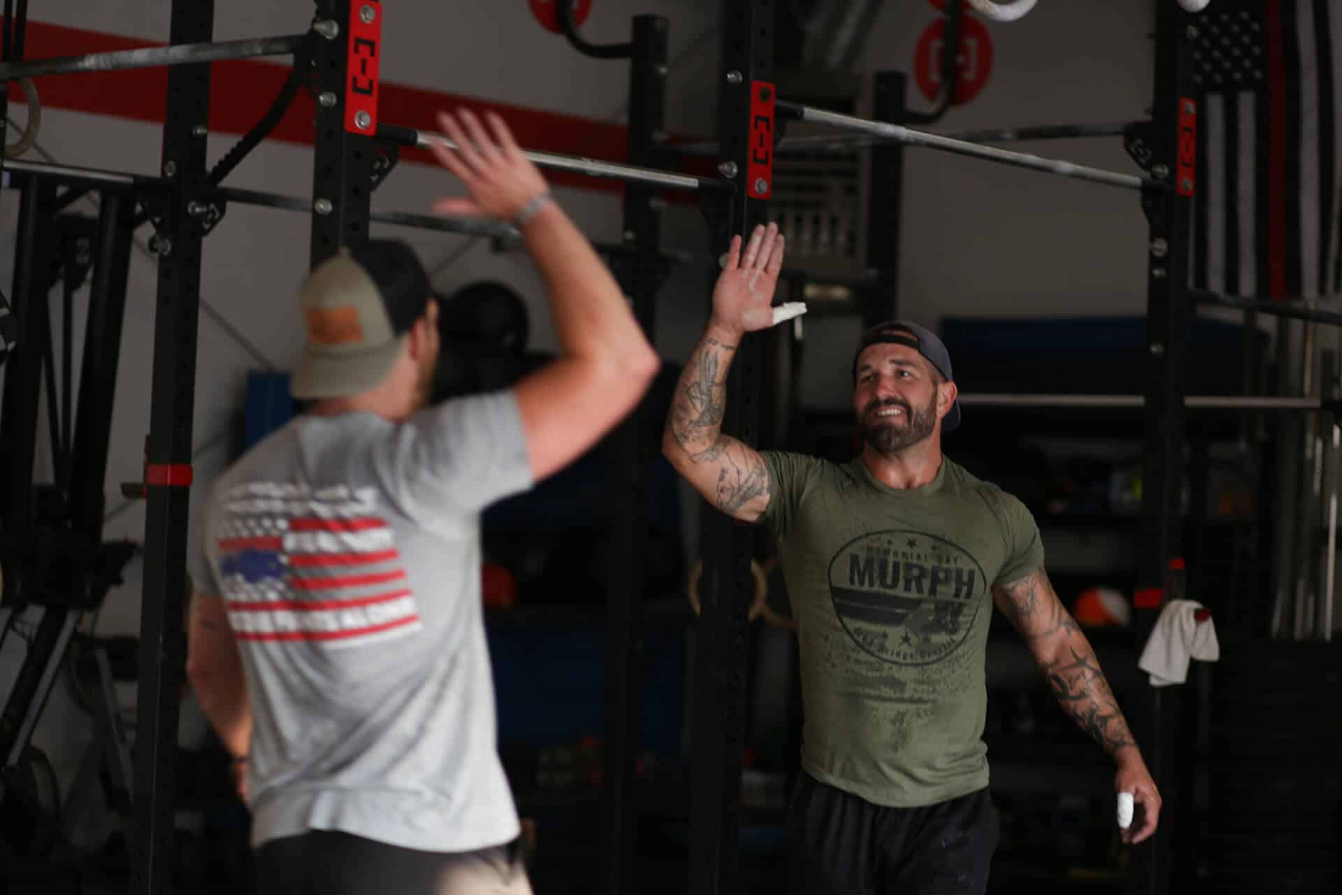 Two veterans celebrating with a high five in a WarriorWOD fitness session.