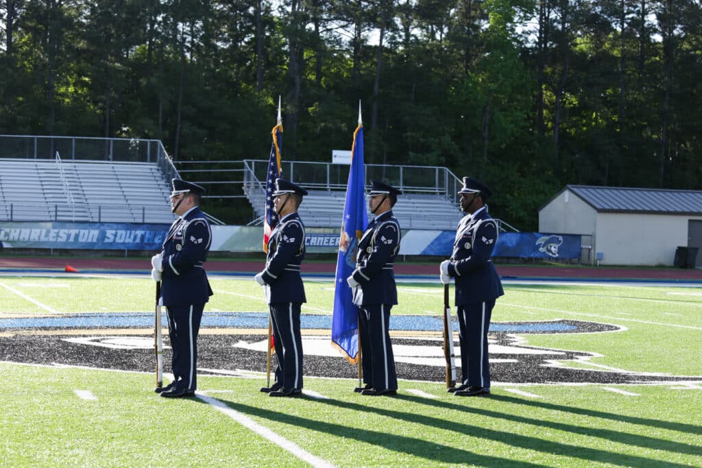 Air Force honor guard presenting the colors on the field at Charleston Southern University during the Hustle for Heroes 5K opening ceremony